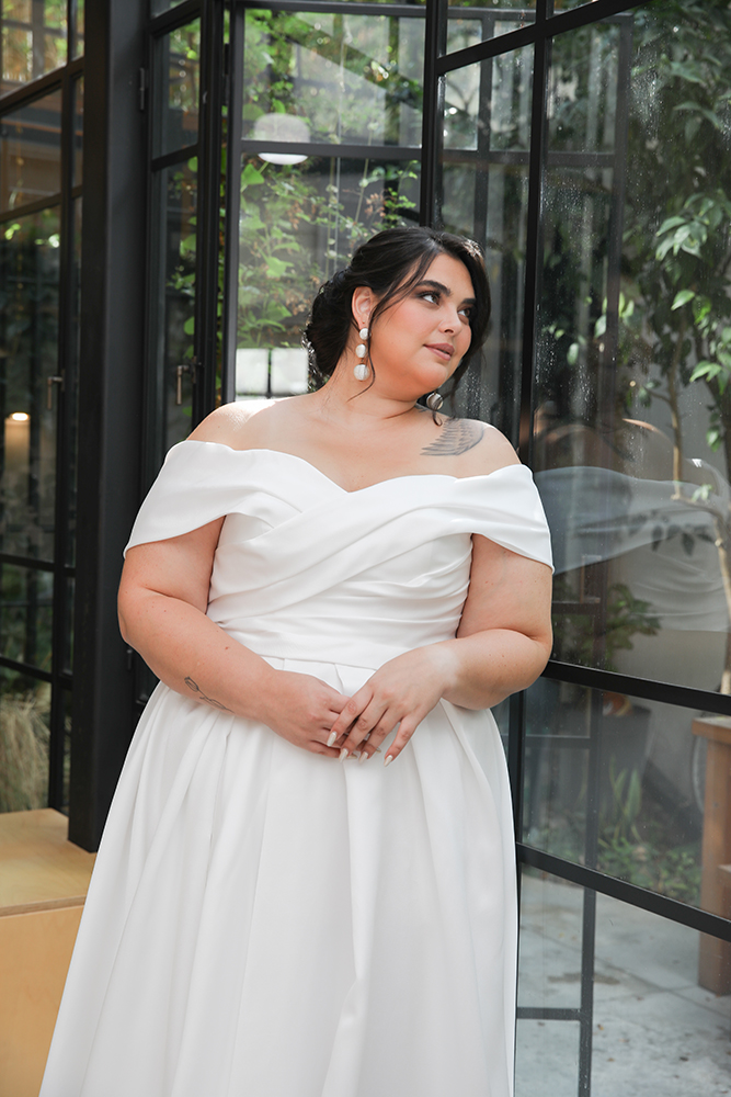 Poppy wedding dress by Studio Levana featuring a plus-size Mikado silhouette with off-the-shoulder straps and a ruched bodice