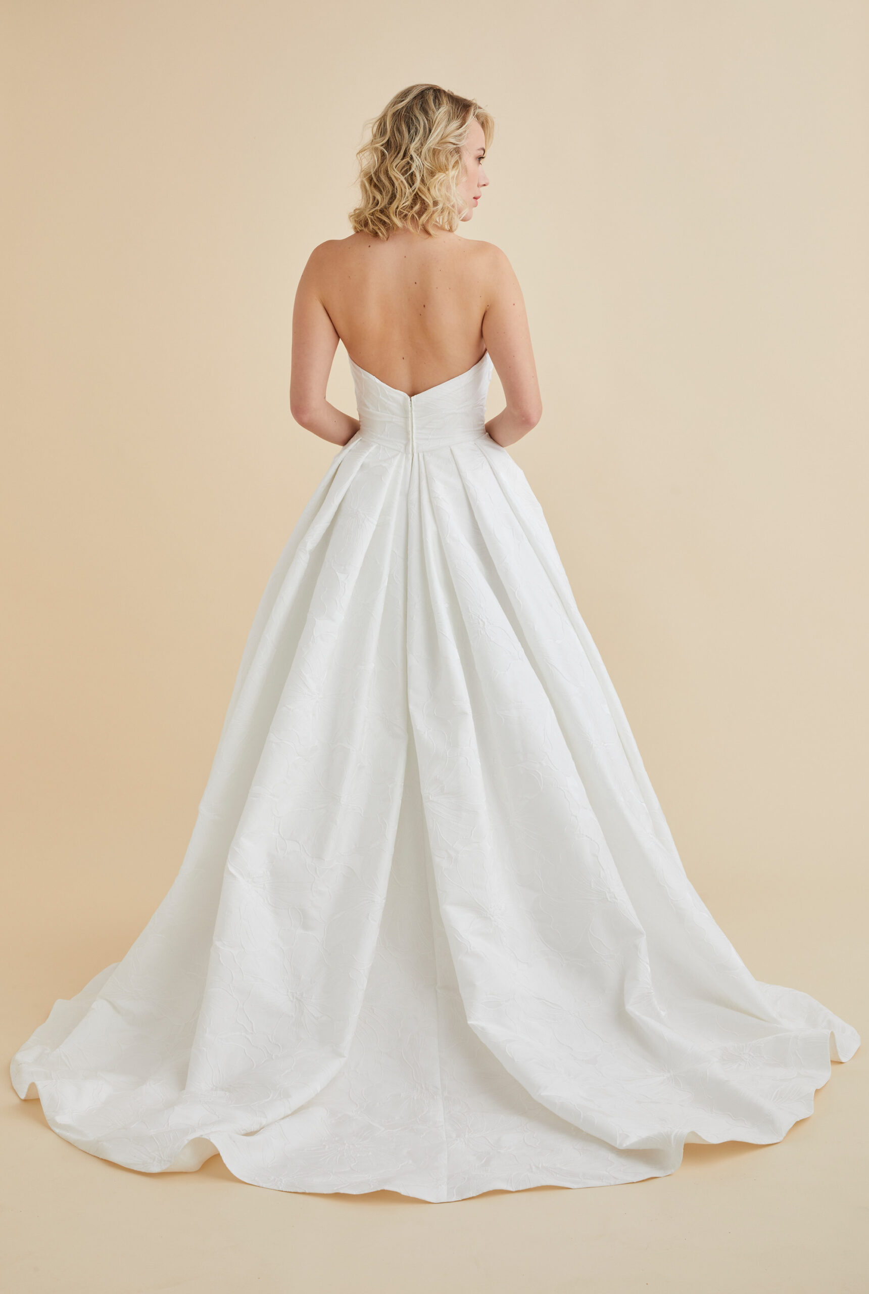 Astrid & Mercedes Aura wedding dress in hibiscus jacquard with ruched sweetheart bodice, low back, inverted-pleat full skirt, and chapel-length train