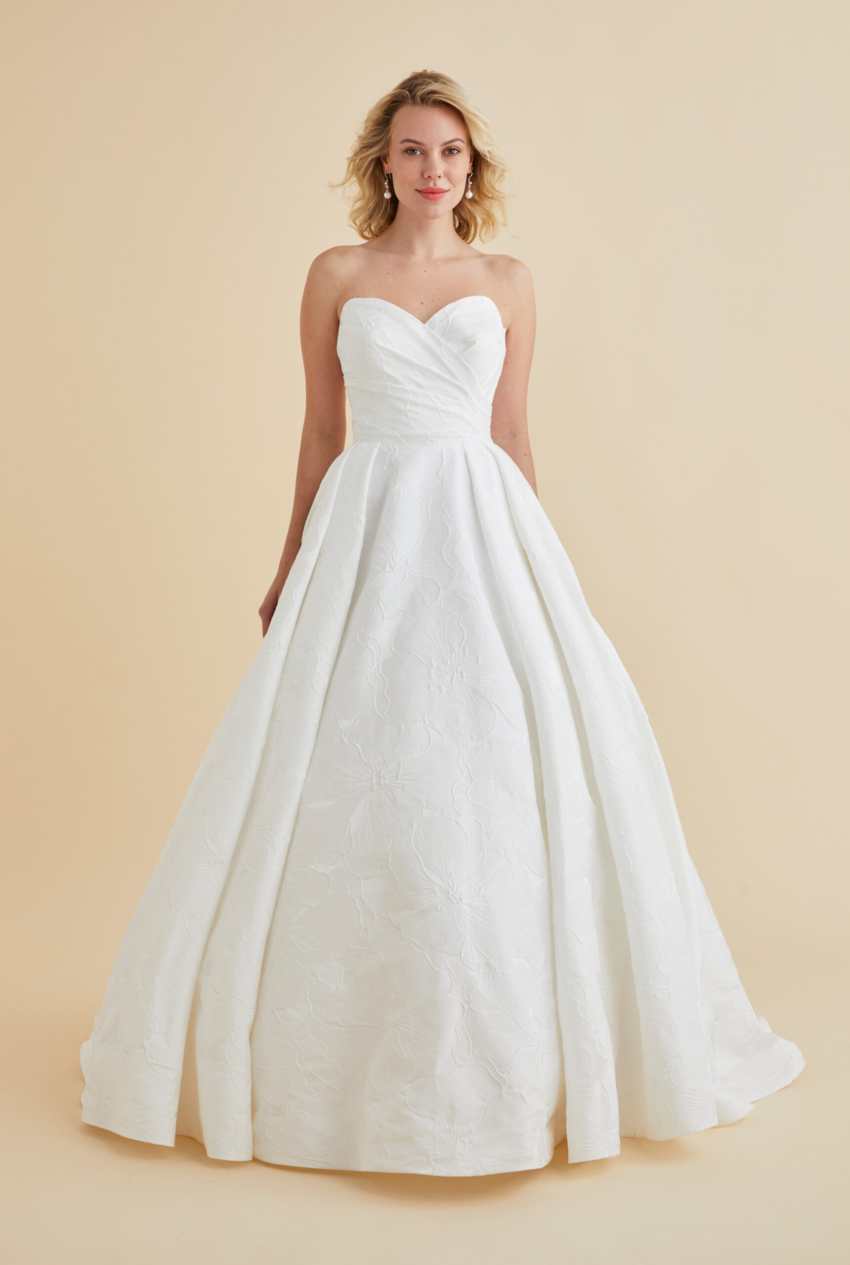 Astrid & Mercedes Aura wedding dress in hibiscus jacquard with ruched sweetheart bodice, low back, inverted-pleat full skirt, and chapel-length train
