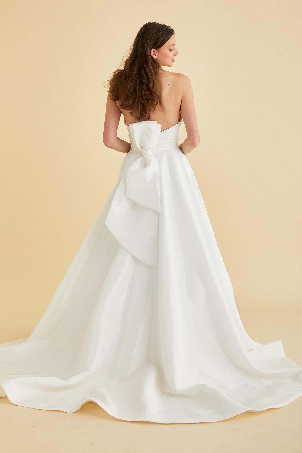 Ivory Astrid & Mercedes Jewel wedding gown—sweetheart ruched bodice, A‑line full circle taffeta skirt with pockets, thigh‑high slit, and vertical statement back bow