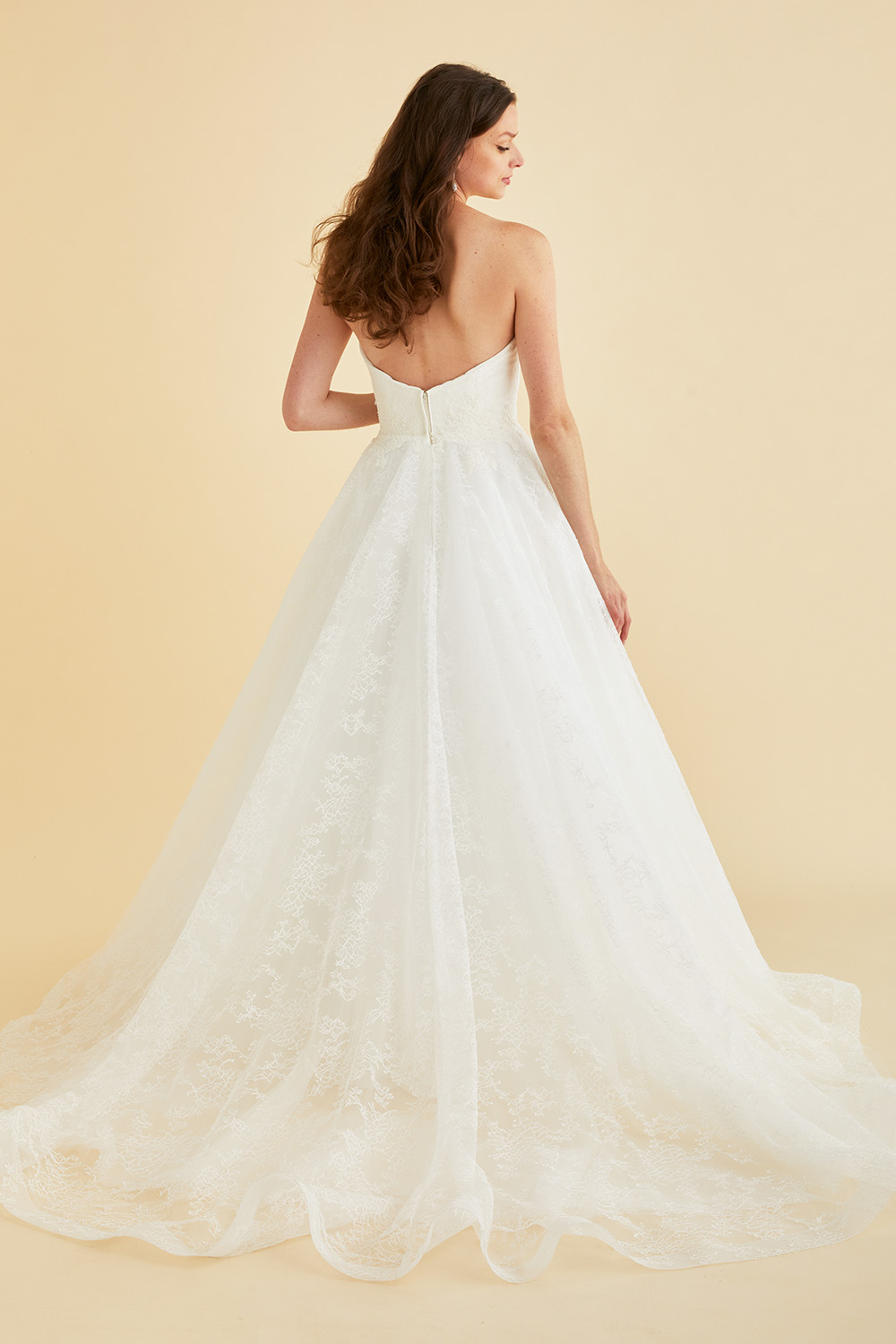 Strapless Astrid & Mercedes Paradise bridal gown by Lea‑Ann Belter in off‑white Chantilly lace, featuring a sweetheart bodice, low open back, natural waist, full circle skirt, and sheer chapel train