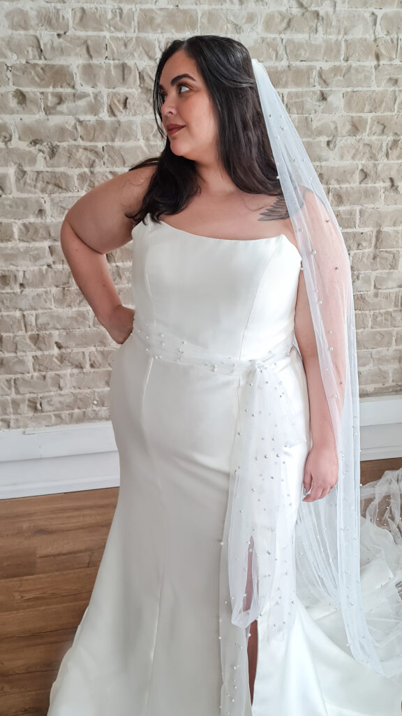 Mariee wedding dress by Studio Levana featuring a sleek mermaid silhouette, boat neckline, and thigh-high slit