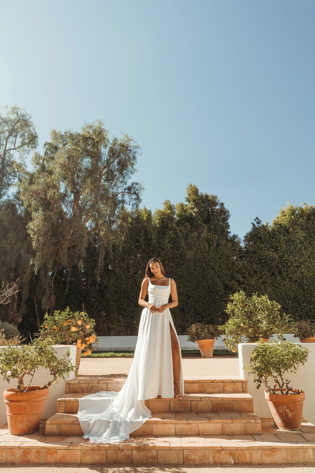 Stella York wedding dress SY8110 featuring a square neckline, ruched satin bodice, and modern A-line silhouette with optional high slit