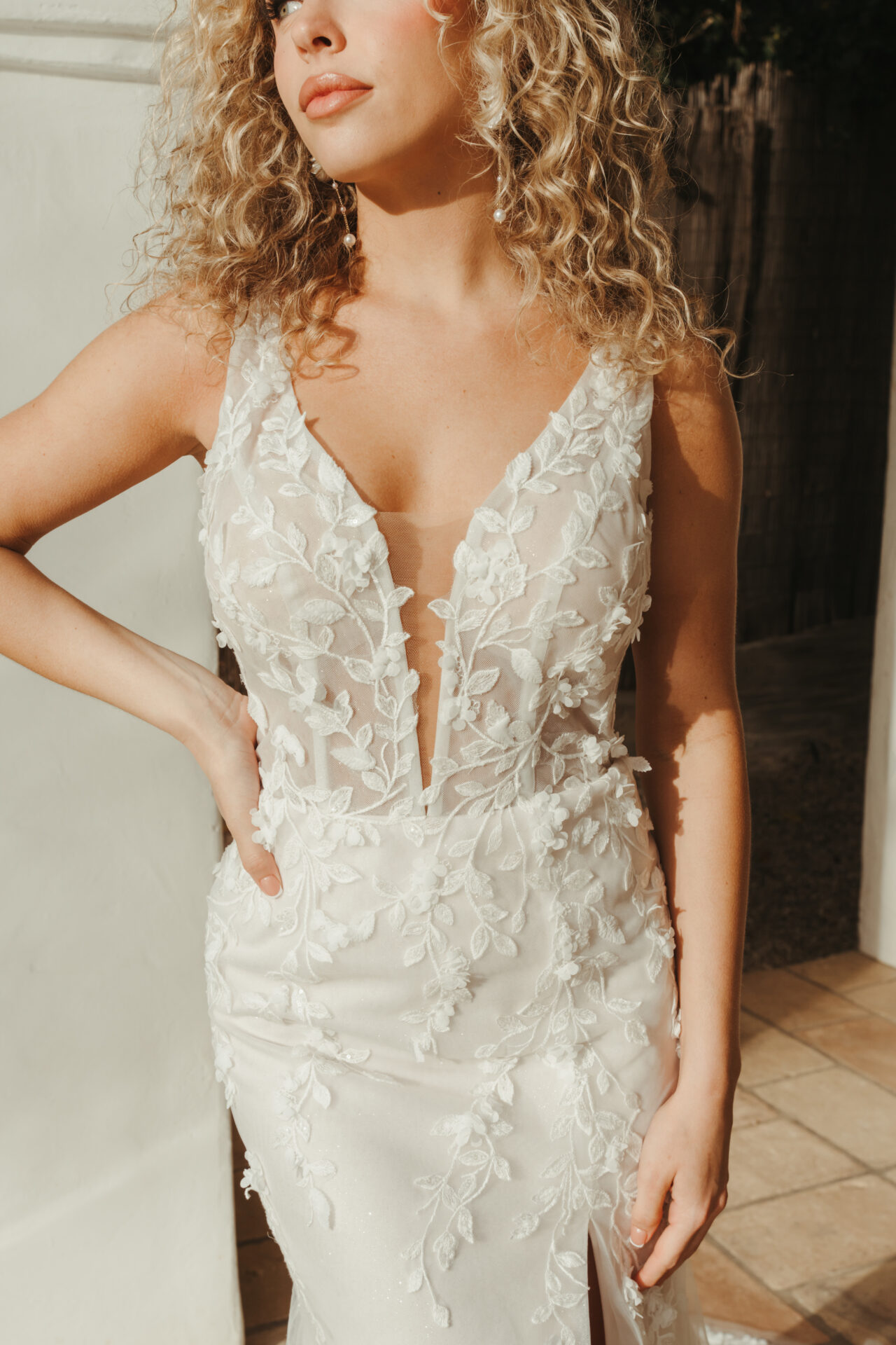 Stella York wedding dress Style SY8157 featuring glitter tulle, floral lace, and a fit-and-flare silhouette with a plunging neckline