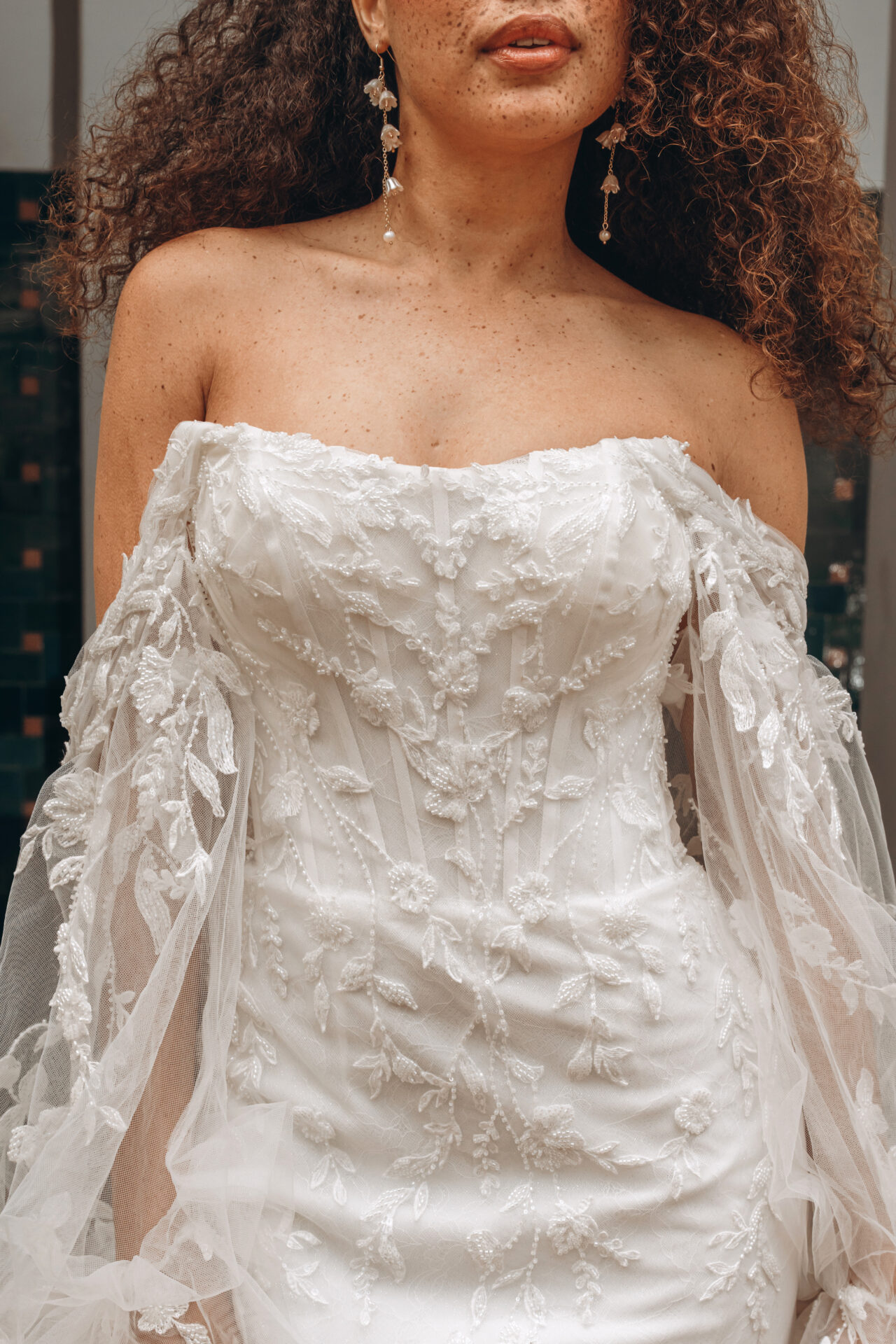 Stella York wedding dress Style SY8160 with detachable off-the-shoulder sleeves, corset bodice, and flowing tulle skirt